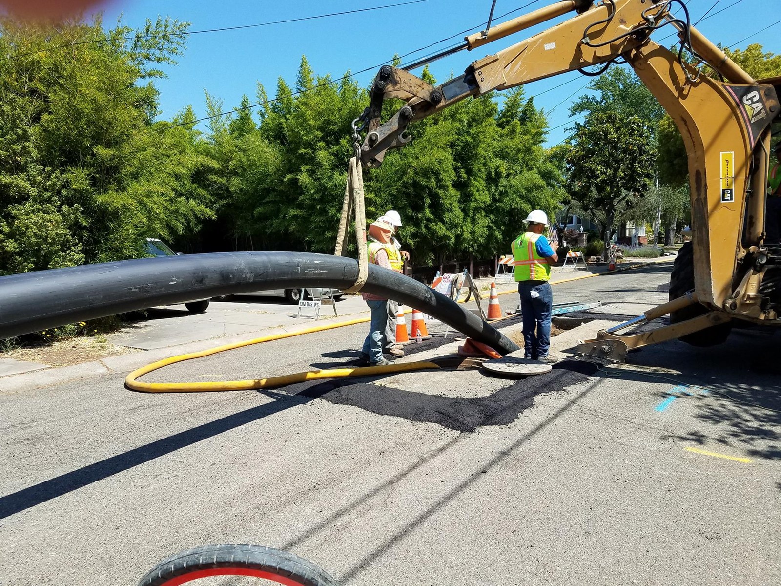 Crews installing sewer pipe during street construction